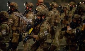 Federal agents walk toward a crowd of protesters in Portland, Oregon.