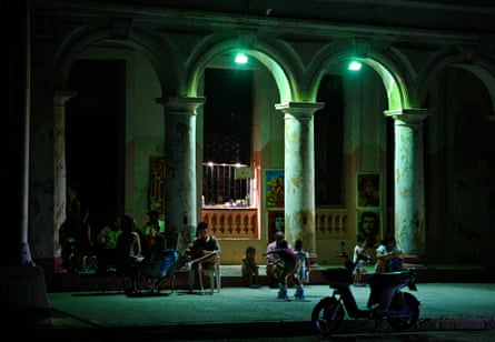 people sit outside on a dark street