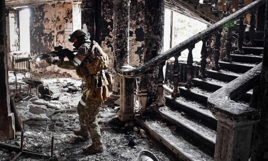 A Russian soldier patrols at the Mariupol drama theatre hit by an airstrike in March.