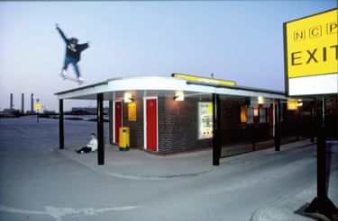A person on a skateboard jumping over the roof of a building