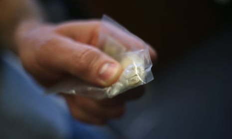 A police officer holds a bag of heroin confiscated in the US.