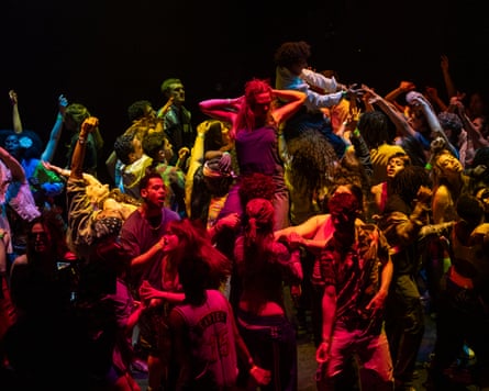 A crowd of dancers bathed in multicoloured light