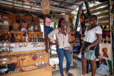 Two women pose in front of their stall displaying products from their local business. San Basilio de Palenque - Colombia. October 11, 2025