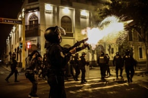 A riot policeman fires teargas canister at demonstrators as people march to the government palace to protest against Merino on 10 November
