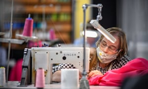 One of several volunteers at Thomas Rae tailors in Glasgow works making free scrubs for NHS nurses and doctors.