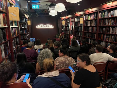people, mostly women, gather at a bookstore