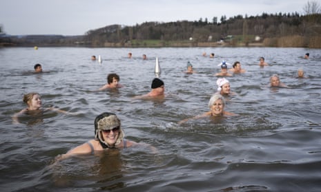 Los nadadores nadan durante el tradicional nado Sylvester en el lago Moossee en Moosseedorf, Suiza.