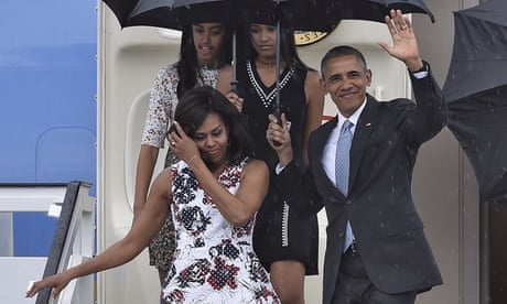 US President Barack Obama waves next to First Lady Michelle Obama (L) and their daughters Malia (L, behind) and Sasha upon their arrival at Jose Marti international airport in Havana
