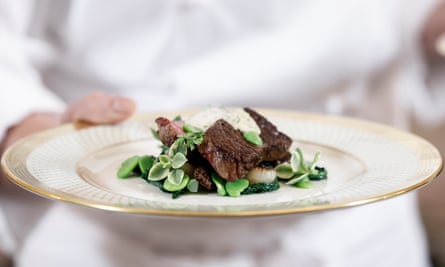 White House executive chef Cris Comerford holds the main course dish of dry-aged rib eye steak, blistered shishito pepper butter, fricassee of fava beans, morels and cipollini sesame oil sabayon.