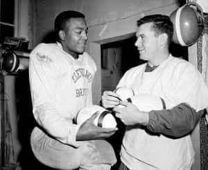 Cleveland Browns fullback Jim Brown, left, with quarterback Tommy O’Connell, autograph footballs before a championship game with the Detroit Lions in Detroit in December 1957