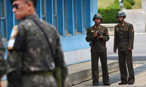 North Korean soldiers (right) look at the South side in the demilitarised zone on the border between North and South Korea.