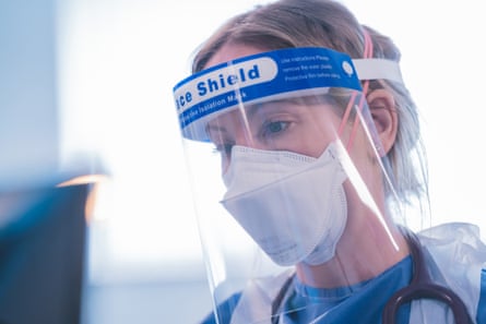 An actor dressed as a doctor wearing face shield and face mask.