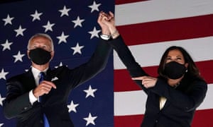 Joe Biden and Kamala Harris, raising each other's hands.