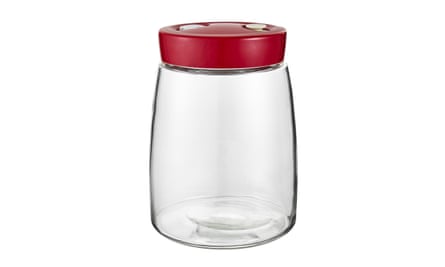 A glass mason jar with a red lid