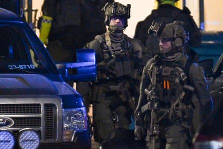 Police special forces are seen leaving the scene at the Risbergska school in Orebro.