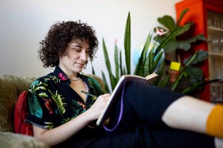 Person sitting on armchair at home and writing in a diary