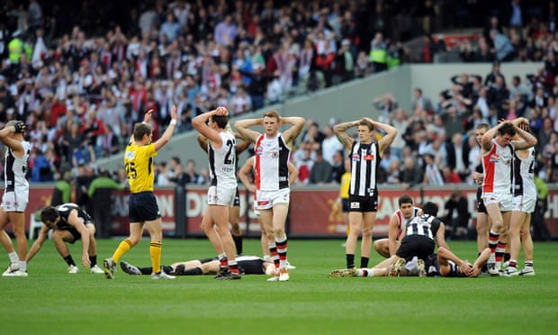 St Kilda and Collingwood players stand with their hands above their heads after the 2010 AFL grand final ended in a draw
