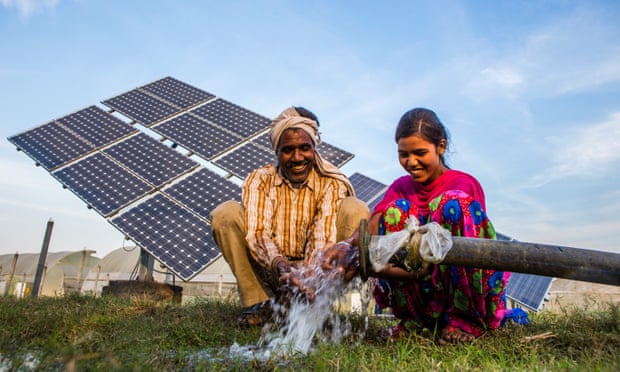 Sukhdev Vishwakarma and his daughter, Meenu, use water pumped from a solar water pump at a farms in Jagadhri.