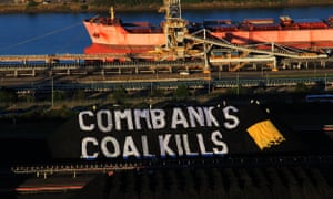 Greenpeace activists unveil a giant banner on Newcastle coal stockpiles, calling on the Commonwealth Bank to stop investing in coal