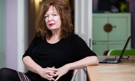 Suzanne Moore sitting, side on to a desk, with a laptop on it