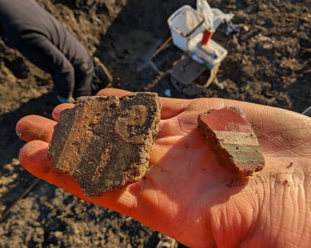 A hand holding fragments of plaster