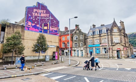 Two people push a pram across a road in Port Talbot