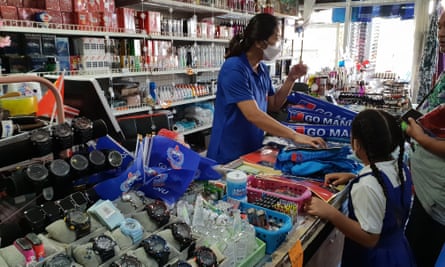 Shopkeeper in blue T-shirt selling flags and other merchandise