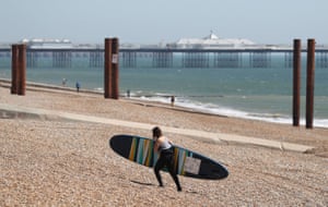A paddle boarder makes her way out of the sea in Brighton
