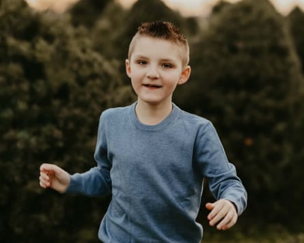 Boy in long-sleeved blue shirt faces forward