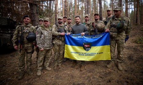 Volodymyr Zelenskiy poses for a picture with service members as he visits a position of Ukrainian troops in a frontline, in an undisclosed location, in Ukraine.