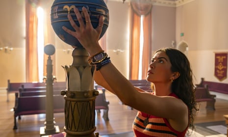 Young woman gazes at globe type object she is holding