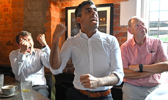 Rishi Sunak and MP John Glen watching the match at the Bishops Mill pub in Salisbury, England.