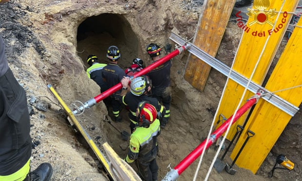 First responders inspect a tunnel discovered following the collapse of part of a road in central Rome