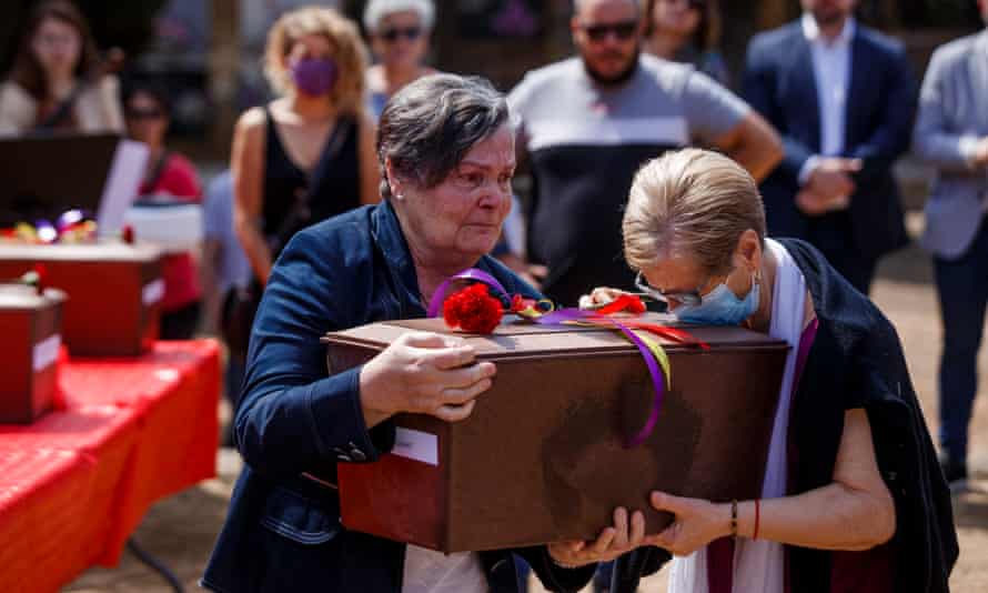 Las dos niñas sostienen una caja que contiene los restos humanos de su abuelo.