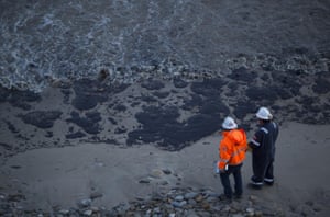 Officials inspect the oil-covered beach after about 21,000 gallons spilled from the pipeline near Refugio State Beach, spreading over about four miles of beach within hours.