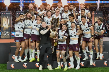 Broncos players celebrate with the trophy after winning the grand final