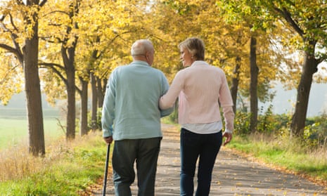 A woman arm in arm with an elderly man with a walking stick