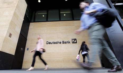 Pedestrians walk past the offices of Deutsche Bank in central London.