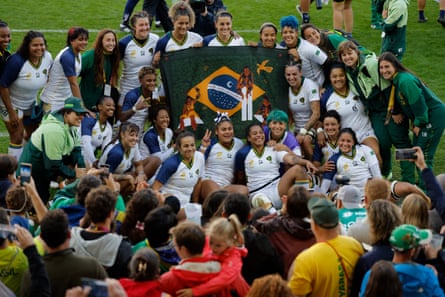 The Brazil players pose together with a flag after their 84-5 loss to France.