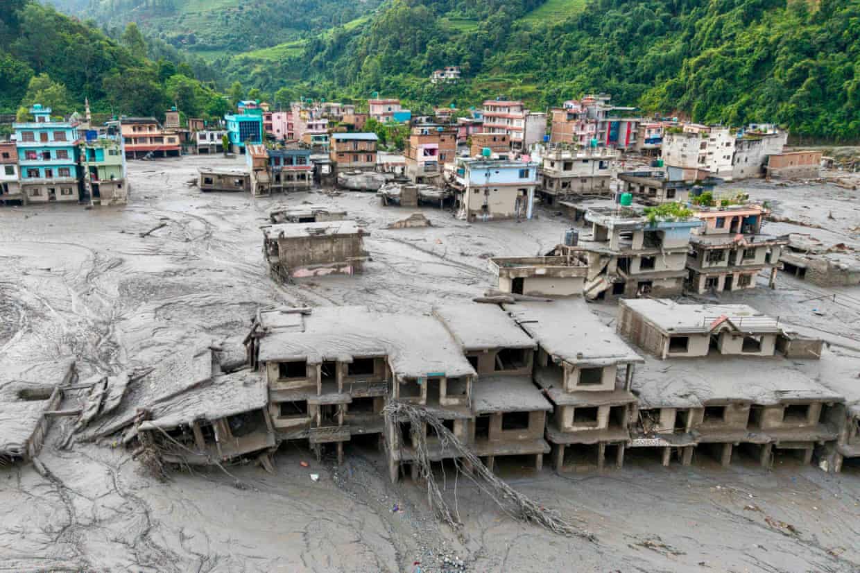 Aerial view of homes sitting amid a lake of mud, with some covered in the sludge