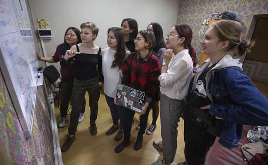 Eight female Kyrgyz scientists have a discussion around a whiteboard