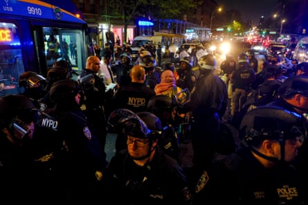 Police escort protesters onto a bus
