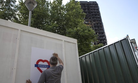 Posters are put up near to the charred shell of Grenfell Tower after the fire which killed 71 people.