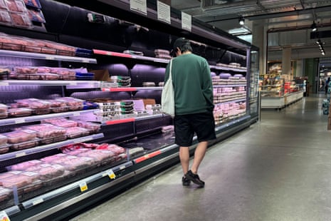 A man looks at groceries in the cold section of a large store