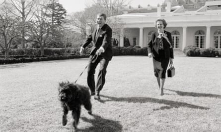 Ronald Reagan and Margaret Thatcher walk Reagan’s dog Lucky on the White House lawn.
