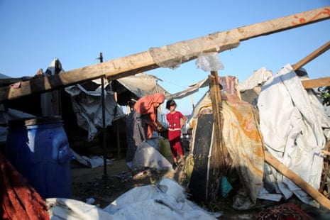 Palestinians stand amid the damage at the site of an overnight Israeli airstrike on a tent sheltering displaced people, in Khan Younis, southern Gaza Strip, 9 July 2025.