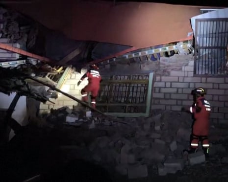 Rescuers use a torch while searching through building ruins in Nagqu city after the 7.0-magnitude quake in the northern Tibet region of China on Thursday night