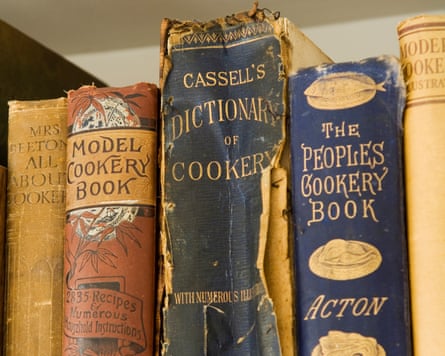 Antique recipe books on a shelf.
