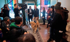Bailey, Elizabeth Warren’s golden retriever, is led by her husband, Bruce Mann, and son Alex in Waterloo, Iowa, on 29 January.