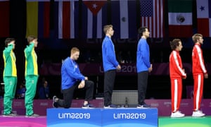 Gold medalist Race Imboden of the United States takes a knee during the national anthem for fencing at the Pan American Games in 2019